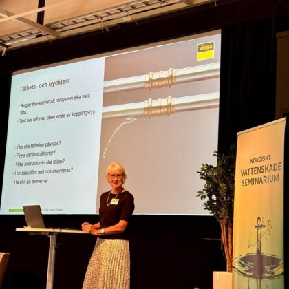 Kvinna föreläser vid Nordiskt Vattenskadeseminarium med presentation om täthets- och trycktest av rörsystem.