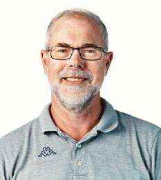 Leende man med glasögon, skägg och grå pikétröja