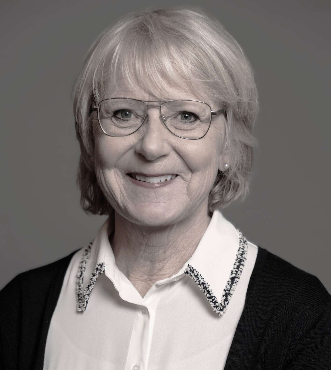 Äldre kvinna som ler och har glasögon på sig